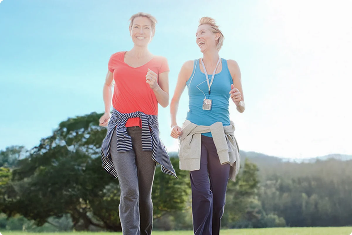 Dos mujeres corriendo en un parque 