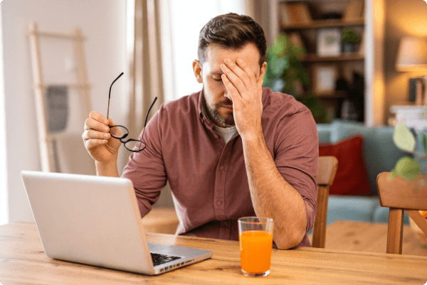 hombre tocandose la cara mientras se quita las gafas