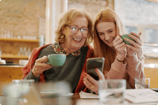 abuela y nieta riendo mirando el móvil