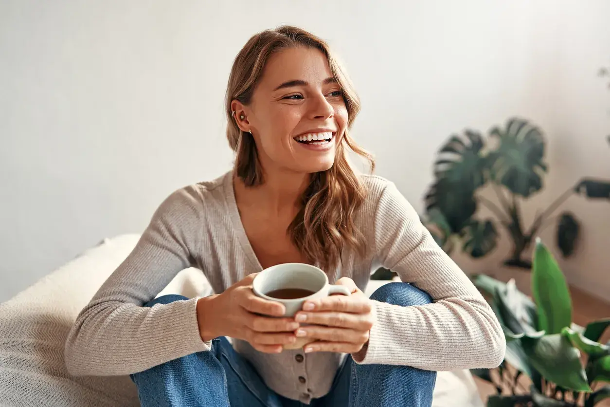 Chica con café en las manos sonriendo