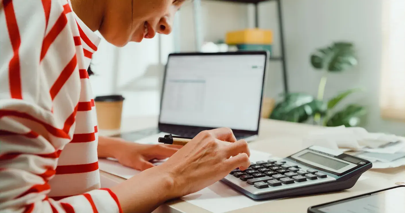 Mujer usando ordenador y calculadora