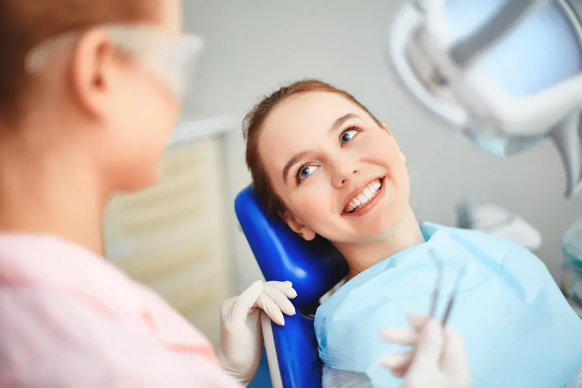 chica sonriendo en silla de dentista