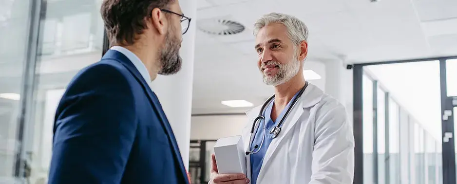Médico con paciente con traje en consulta