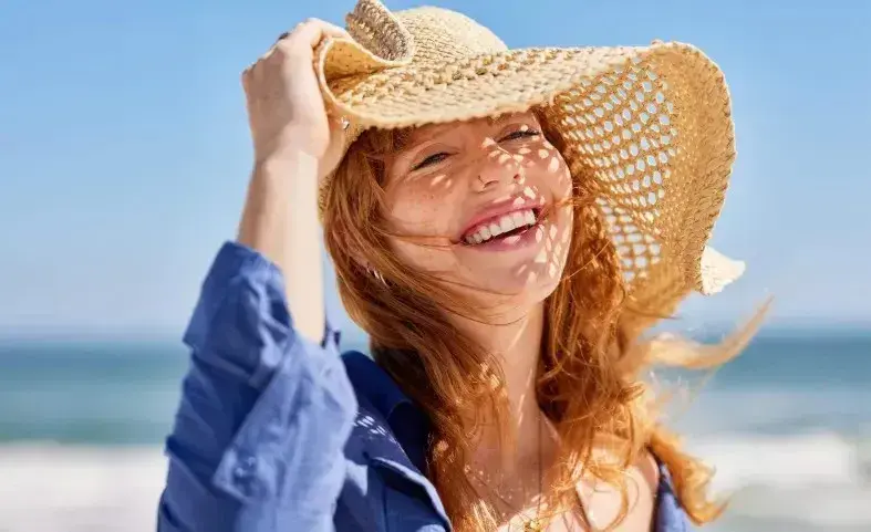 mujer con sombrero en la playa